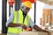 African American worker is packing product in cardboard box while working in warehouse with full safety equipment for distribution