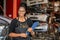 African american worker woman wear spectacles crossed arms holding clipboard standing in factory auto parts.