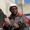 African american workman with smartphone at construction site