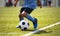 African American young boy playing soccer in a stadium pitch