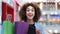 African american young girl curly hair woman shopper consumer buyer client in shopping mall opens package looking inside