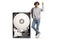 African american young man leaning on a big hard disk and pointing up