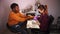 African american young man sits in a spa salon when female master in mask polishes his nails