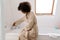 African american young woman filling bathtub with water in morning