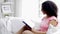 African american young woman reading book at home