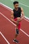 African athlete man make stretching exercises on running track