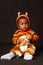 African baby boy sitting  dressed in a tiger costume