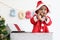 African baby kid in Santa Claus red costume standing in big gift box present at white room, beautiful little child celebrates