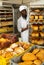 African baker pushing rack trolley with baked loaves