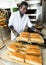 African baker taking out bread from baking molds