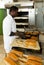 African baker taking out bread from baking molds