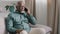 African bald middle-aged man senior mature businessman sitting on sofa at home in office talking phone chatting mobile