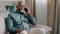 African bald middle-aged man senior mature businessman sitting on sofa at home in office talking phone chatting mobile