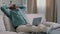 African bald overweight obese old middle-aged man senior businessman sitting on sofa at home working with laptop typing