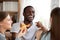 African black cheerful guy eating pizza with friends