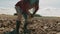 African black farmer picking up soil from ploughed farmland