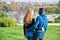 African black man and redhead caucasian woman backwards looking each other in a park