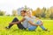 African and blond girl sitting together on grass