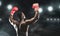 African boxer raising his hands in boxing gloves to audience at stadium