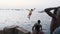 African Boys Teenagers Jump into the Water from High Embankment in Stone Town