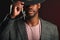 African businessman in grey suit and black hat in studio on dark background