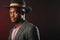 African businessman in grey suit and black hat in studio on dark background