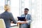 African Businessman Talking to Blond Woman in Meeting