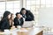 African businessmen standing in the back of Caucasian colleagues with smiles looking on laptop at an internal business group