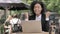 African Businesswoman Celebrating on Laptop in Outdoor Cafe