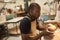 African ceramist working on a clay bowl at a studio bench