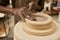 African ceramist working on clay turning in a mold on a pottery wheel