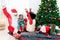 African child sister and Santa Claus celebrate winter holiday together, cheerful cute girl kid and Sata reaching hands up for