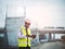 African civil engineer working with use tablet for control the road rebuilding and inspect the construction site with roller