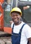 African construction worker with red excavator at construction site