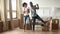 African couple first time home buyers dancing in living room
