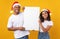 African Couple Holding Empty Christmas Poster Posing In Studio