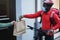 African courier man with thermal backpack and bike ringing the doorbell for delivery service - Focus on face