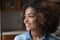 African curly-haired teenage girl smiling staring into distance