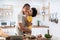 African Cute little boy in yellow casual kissing Dad while cooking at home together. Happy smiling African-American Father while