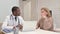 African Doctor Listening Female Patient in Clinic