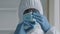 African doctor surgeon medical worker in protective uniform transparent glasses and face mask wears latex gloves holds