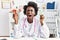 African doctor woman holding anatomical female genital organ and birth control pills angry and mad screaming frustrated and