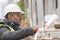 African engineer checking office blueprints on construction site