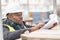 African engineer checking office blueprints on construction site