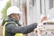 African engineer checking office blueprints on construction site