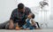 African family, happy father smile and look at little cute daughter toddler baby while playing blocks toy and sitting on floor