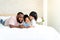 African family time, father an Asian attractive mother and a 5-year-old daughter, lounging in a white bed