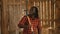 African farmer holding fork over his shoulder in the barn