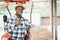 African farmer standing with rice straw bales and tractor. Agriculture or cultivation concept