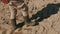 African farmer walking along the plowed soil in the boots. Follow shot